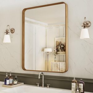 rectangular brass framed mirror with wall sconces in neutral bathroom