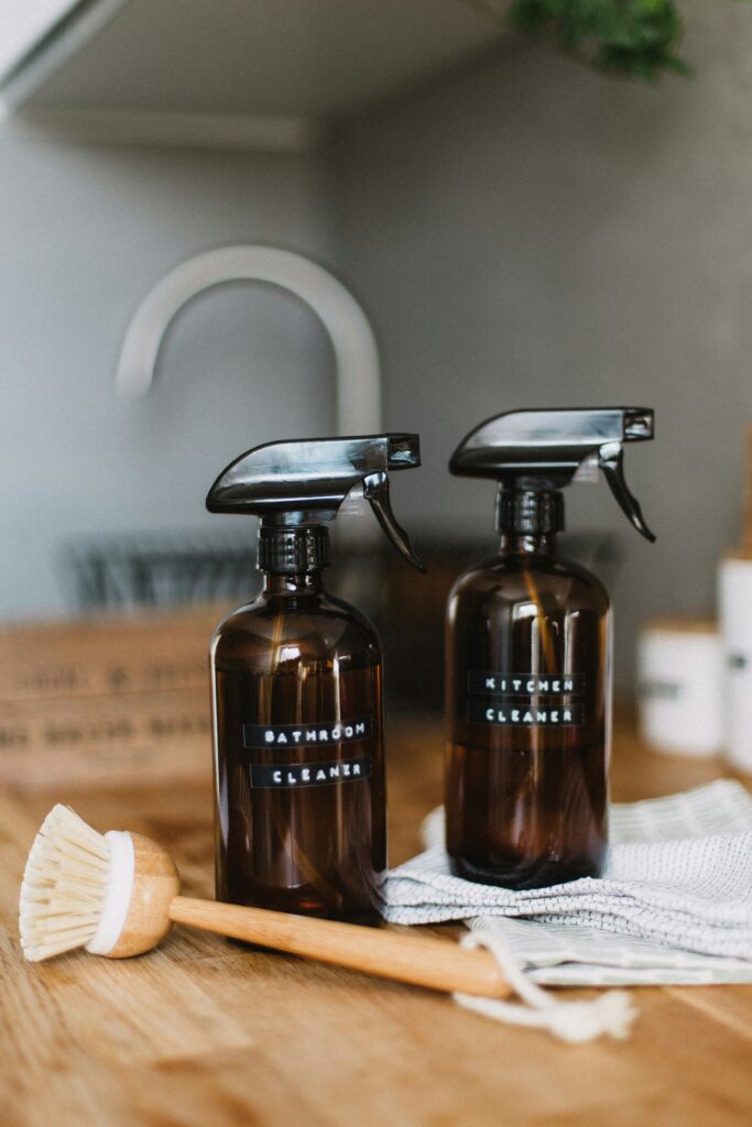 cleaning spray in reusable bottle with wood dish brush