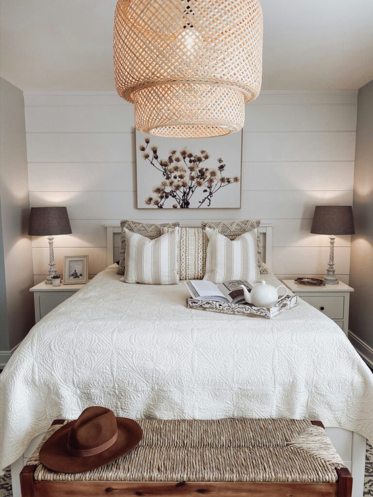 bedroom lights with white bedding and plant photo framed over bed