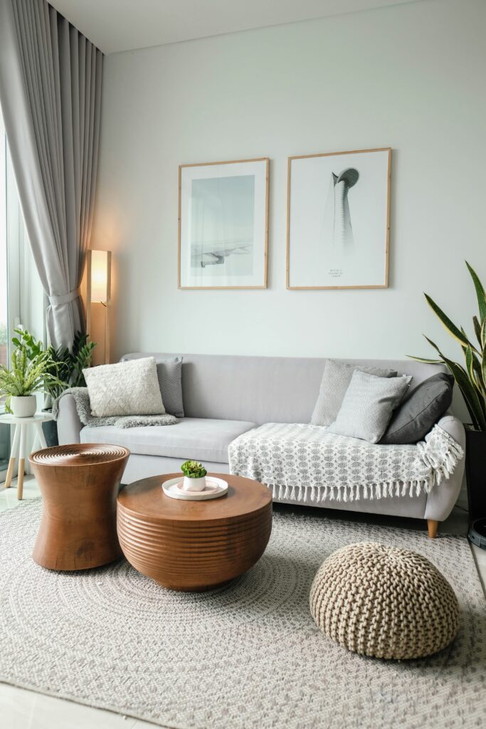 Bright neutral open-concept living room and kitchen with modern decor, warm wood floors, white walls, and minimalist furniture in a light airy home interior.