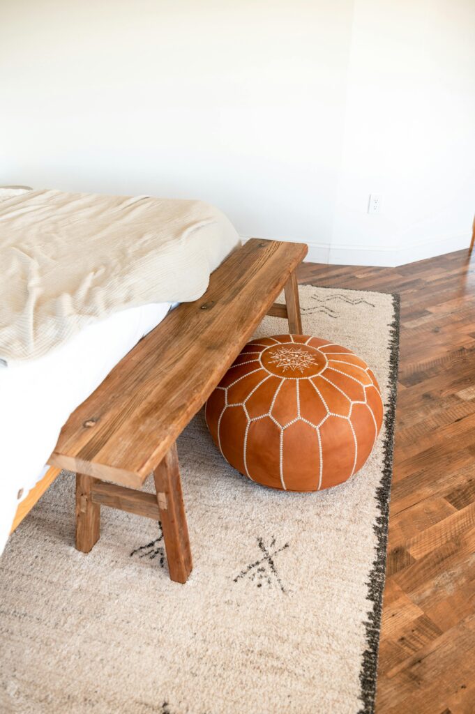 bedroom area rug with wooden bench and white bedding