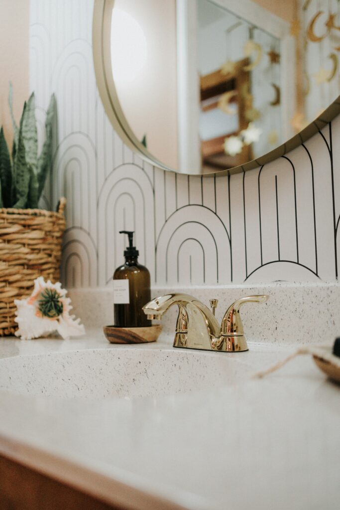 round mirror in bathroom with gold sink