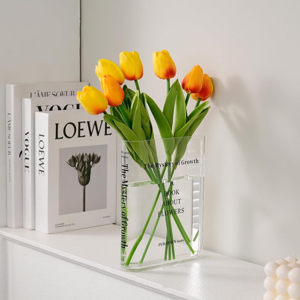 clear vase for book shelf holding orange flowers