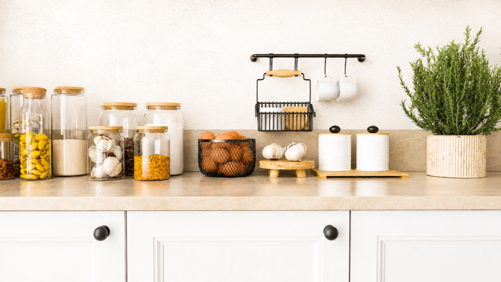 organized kitchen countertop with clear jars and a plant