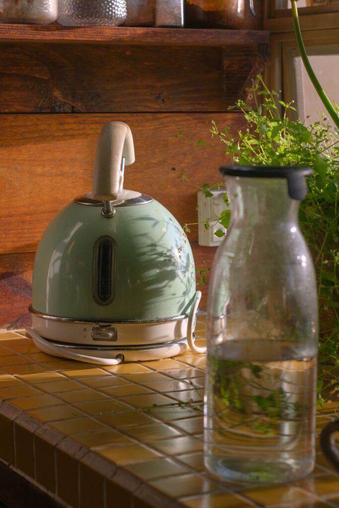 vintage blue tea kettle and clear water pitcher on kitchen counter