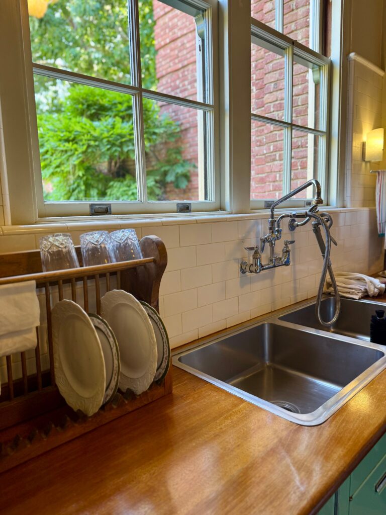 vintage wood drying rack on kitchen counter underneath the window