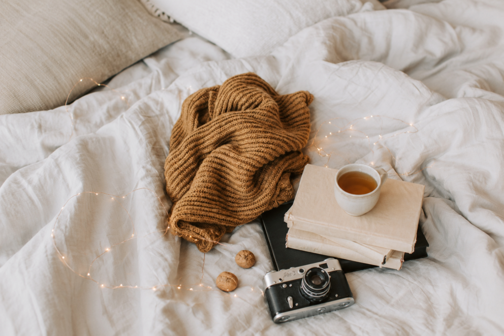 fall bedroom decor with a throw blanket on the bed with a camera and coffee