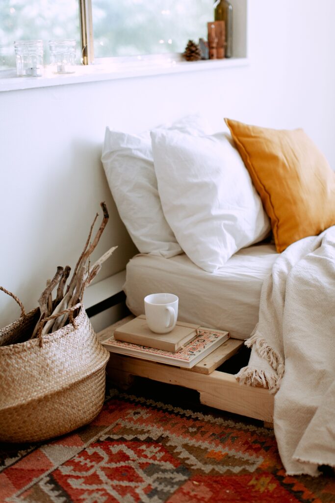 vintage area rug in a bedroom with fall white and orange bedding and a woven basket