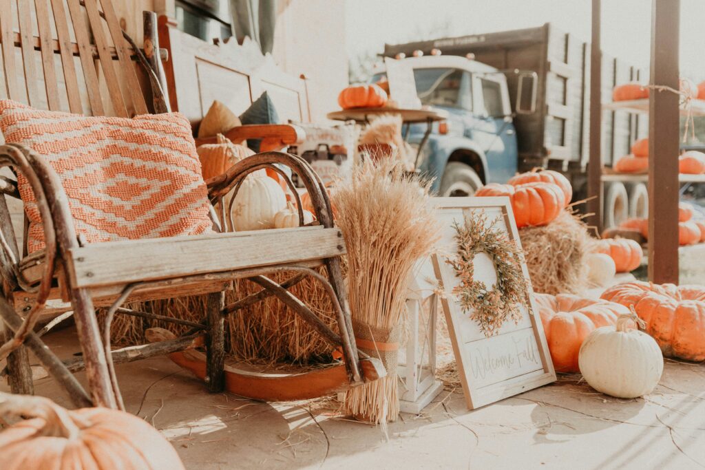 Fall decor including a rocking chair and wreath and throw pillow