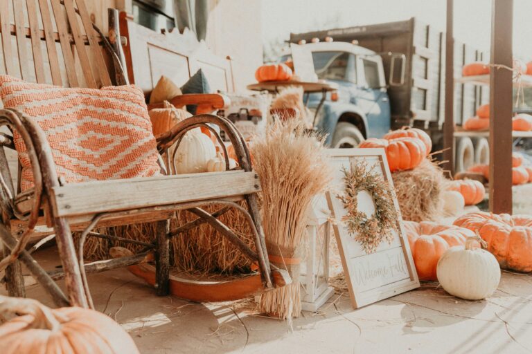 Fall decor including a rocking chair and wreath and throw pillow