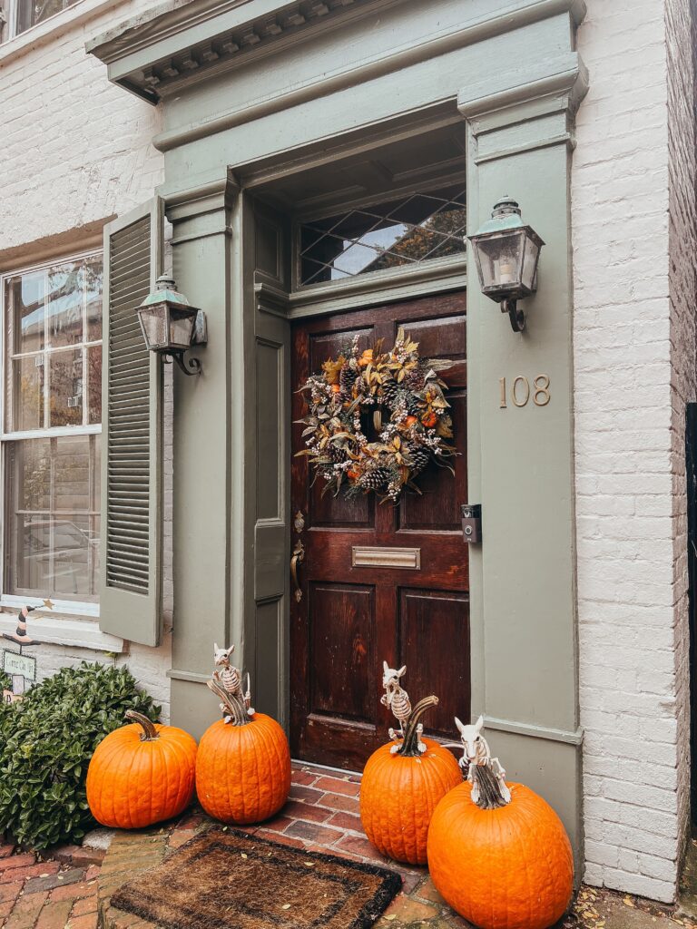 fall front porch decor with a wreath on front door with pumpkins on porch