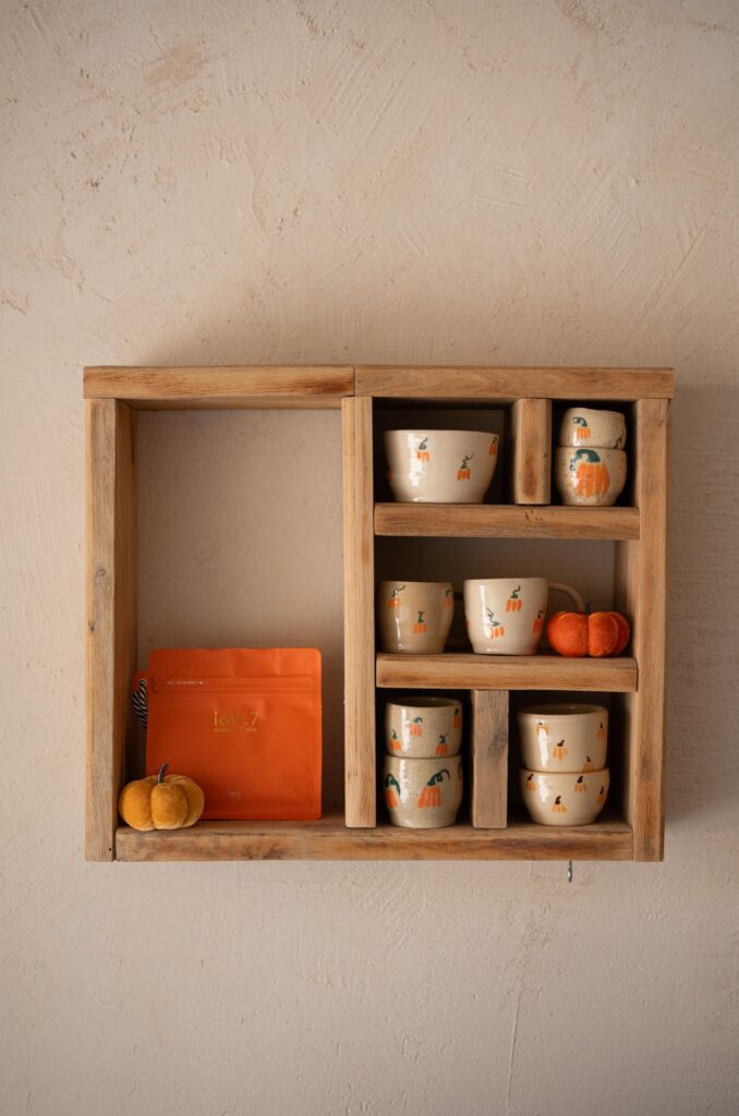 Fall kitchen decor with pumpkin mugs on a floating shelf