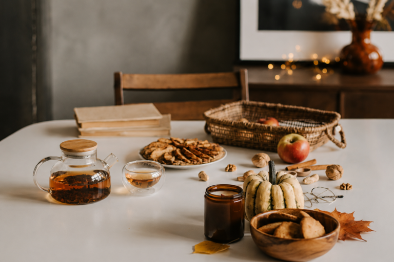 Fall kitchen decor with twinkle lights and pumpkins and coffee pot on the table