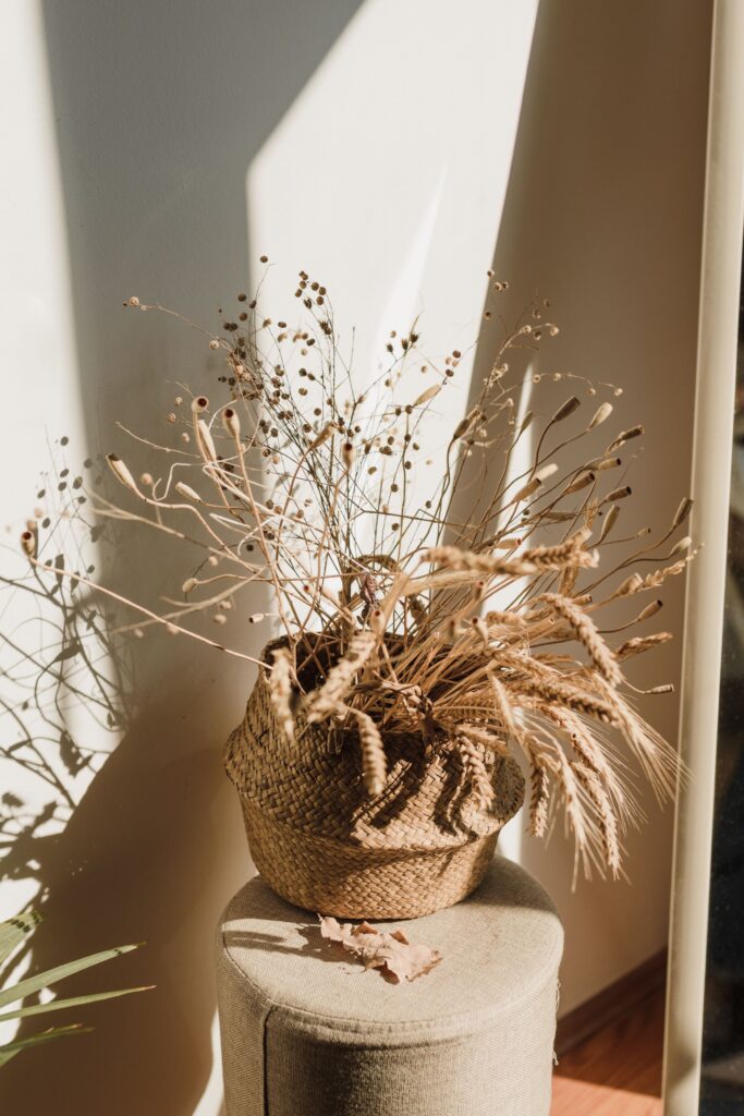 hand woven basket holding dried wheat on a shelf