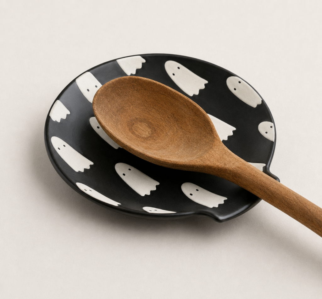 black spoon dish holder with small white ghost on it