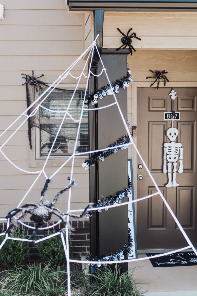 spiderweb with fake spiders on it and along the front door for fall decorations for the home