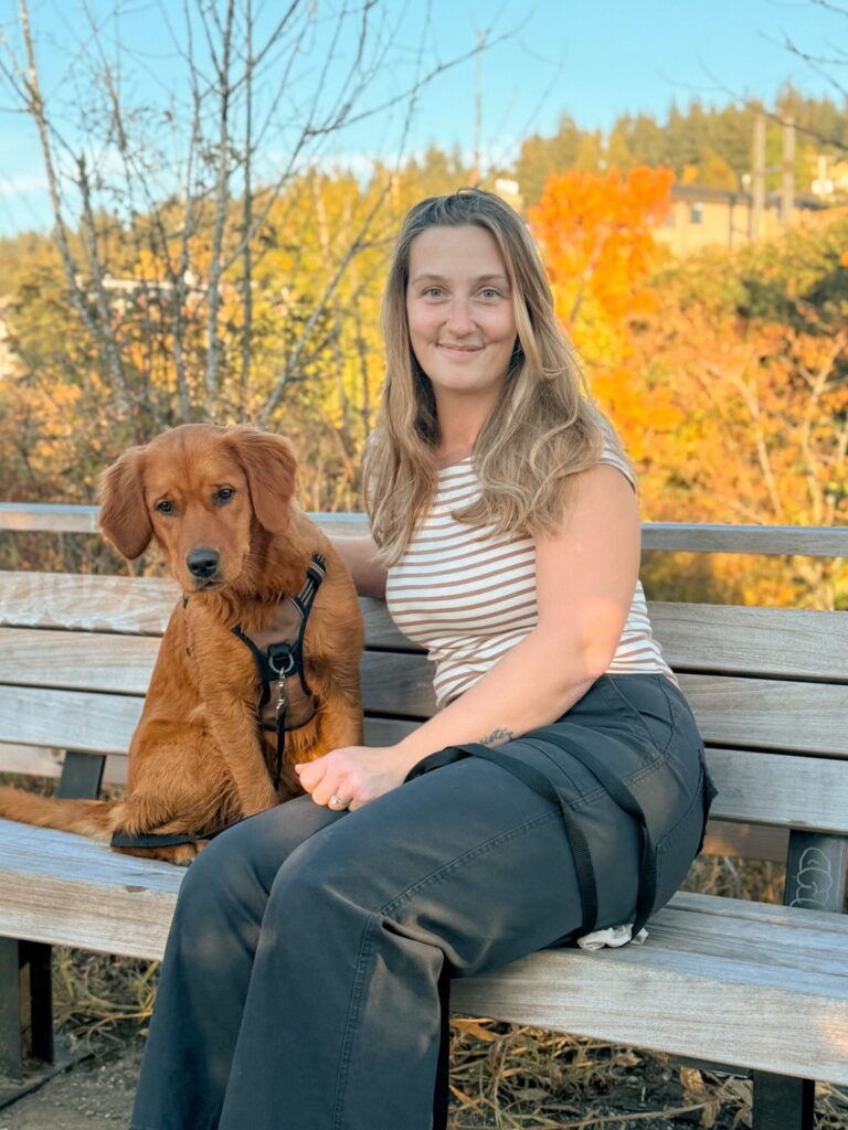 a woman outside posing for a picture with her golden retriever