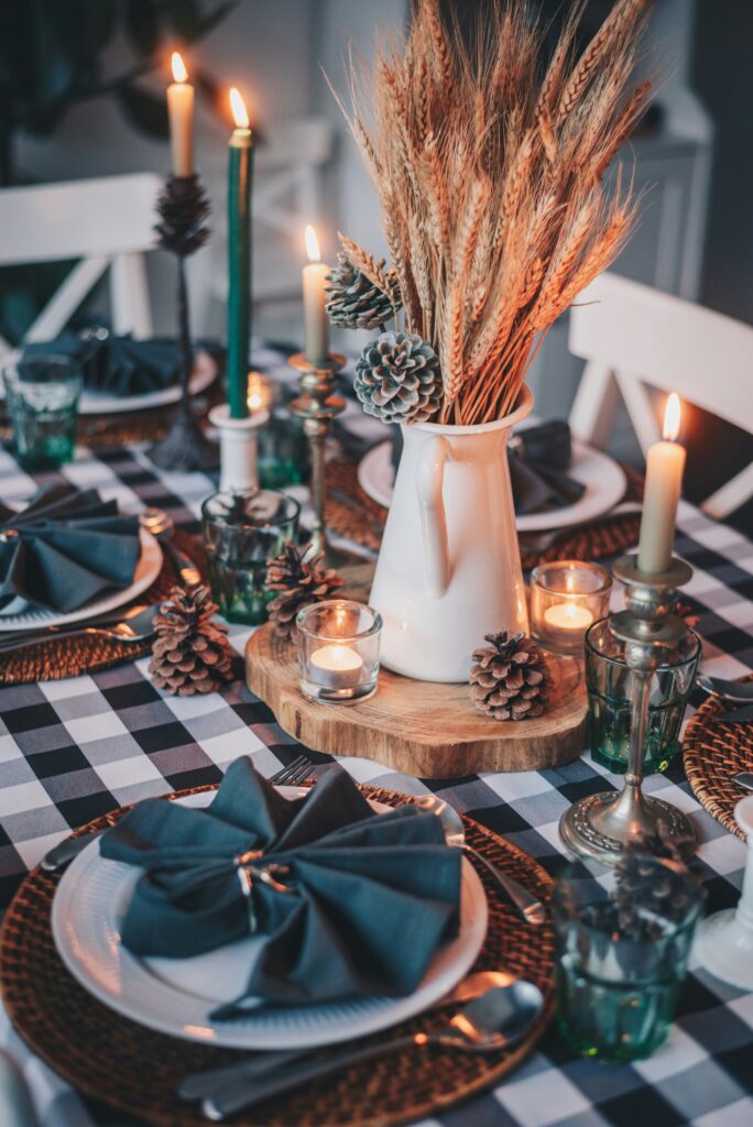 thanksgiving table centerpeice with plates set around the table and napkins on the plates.