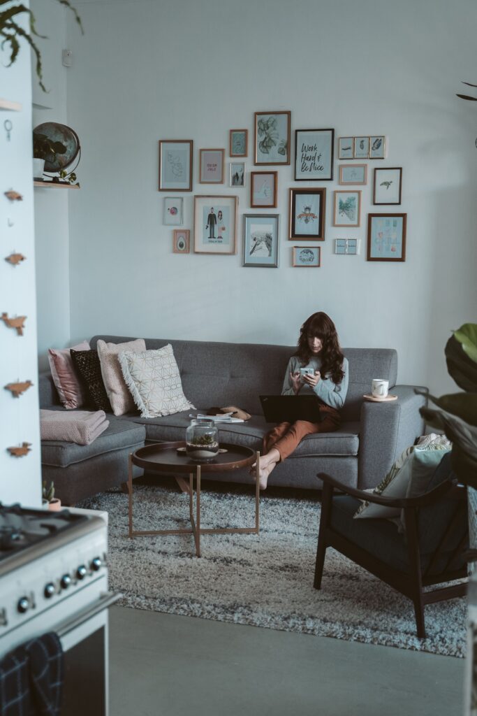 Cozy rental living room with a gallery wall of mixed picture frames above a gray sofa, showing how wall decor adds personality to a space.